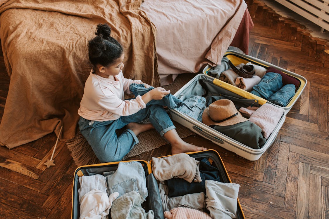 子どもが旅行用スーツケースを準備するイメージ